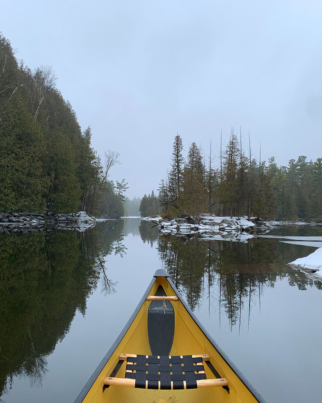H2O Canoe Company Slideshow - Yellow Canoe on Water With Snow on Shoreline